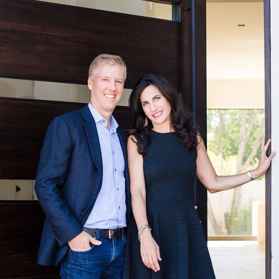 Eric and Janelle Boyenga standing together at the front door of a modern home